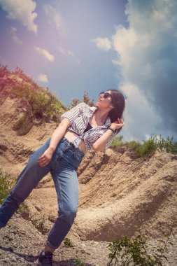 Kumsaldaki güzel esmer kadın rahatla ve güneşli yaz gününün tadını çıkar.