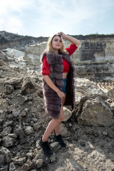 カジュアルな布や毛皮のコートの砂の岩でかわいい女の子 夏の旅行 — ストック写真