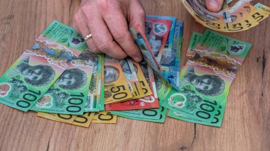 Yeni Avustralya dolarları erkek elinde, finansal savin konsepti. Ödeme maliyeti Kapat