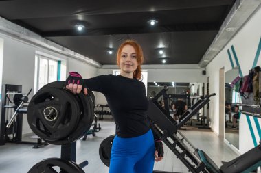 Cana yakın çekici beyaz tenli kadın fitness eğitmeninin portresi müşteriyi spor salonunda bekliyor. Sağlıklı yaşam tarzı