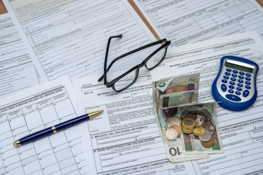 Polonya deklarasyonu PIT-36L, PIT-37 ve PIT-38 vergi formları. Masasında da pln zloty para kalem hesap makinesi gözlükleri var. Ticari vergilendirme kavramı