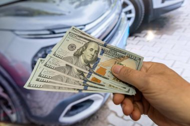 100 dolarlık parası olan adam galeride arabanın yanında duruyor. Kiranın konsepti ya da yeni bir araba almak. Maliye kavramı güvence altına alır