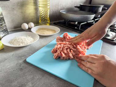 Kadın eli evde mantı ya da pirzola için kıyma yapıyor. Pişmemiş çiğ yemek.