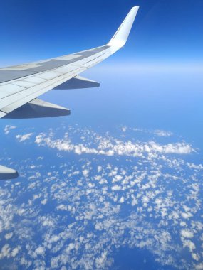 Derin mavi denizin üzerinde uçan uçak penceresinden kıyı manzarası