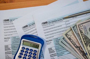 Kişisel veya ticari finans yönetimi için para birimi ve hesap makineli ABD vergi belgeleri