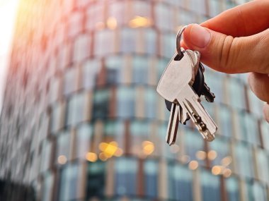 Ev anahtarının ve anahtarlığın yakın plan çekimi, ev sahipliği kavramı.