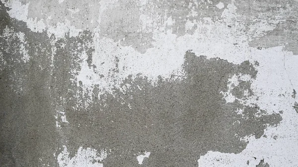 Beyaz boya desenli eski beton duvar. Çatlaklar ve lekelerle yıpranmış. Tasarım ve dekorasyon için endüstriyel grunge arkaplanı.