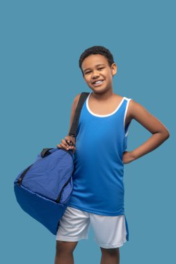 Spor çantalı, mutlu esmer çocuk.