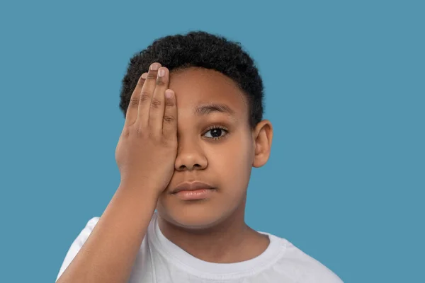 Boy covering one eye with his palm — Φωτογραφία Αρχείου