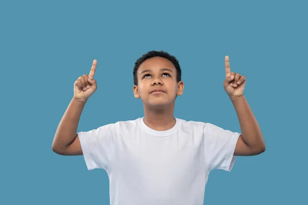 Niño mirando y señalando con el dedo hacia arriba — Foto de Stock