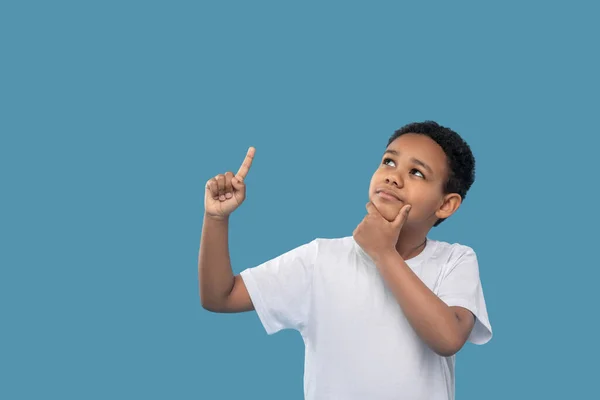 Pensive boy looking up pointing finger — Φωτογραφία Αρχείου