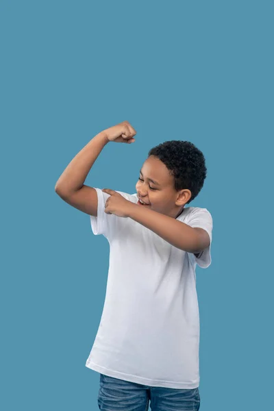 Мальчик радуется своим сильным мускулам — стоковое фото