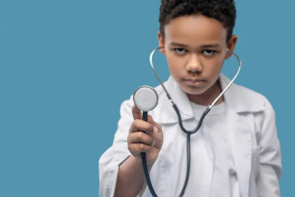 Stetoskop tüpü ciddi bir çocuğun ellerinde. — Stok fotoğraf
