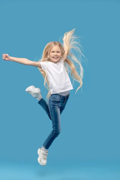 Веселая маленькая девочка прыгает в фотостудию — стоковое фото
