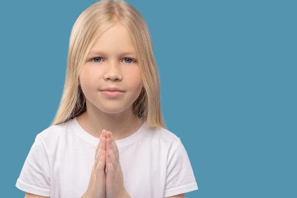 Pequeña linda chica haciendo namaste sobre fondo claro — Foto de Stock