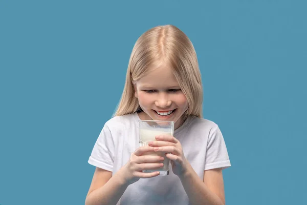 Happy delighted girl looking at glass of milk — Φωτογραφία Αρχείου