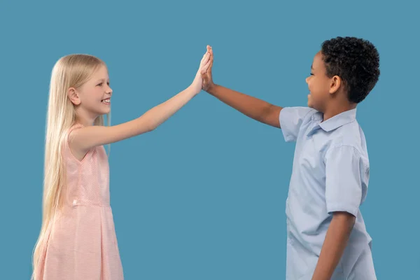 Niño y niña con la mano extendida tocando las palmas —  Fotos de Stock