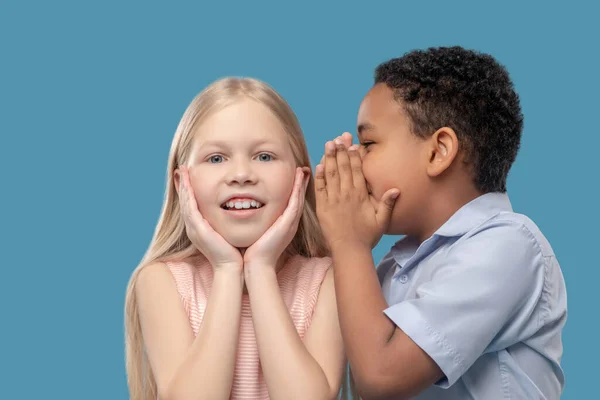 Boy whispering in ear of his surprised girlfriend — Φωτογραφία Αρχείου