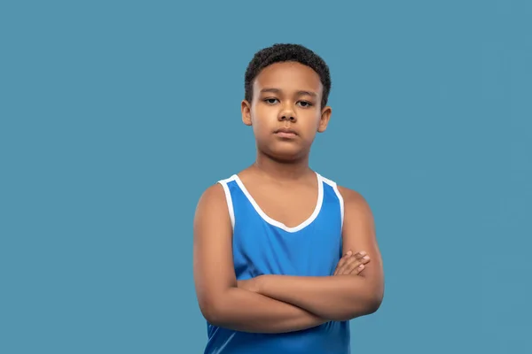 Spor mavisi gömlekli ciddi bir çocuk. — Stok fotoğraf