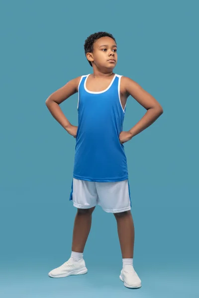 Темнокожий уверенный мальчик в спортивной одежде на синем фоне — стоковое фото