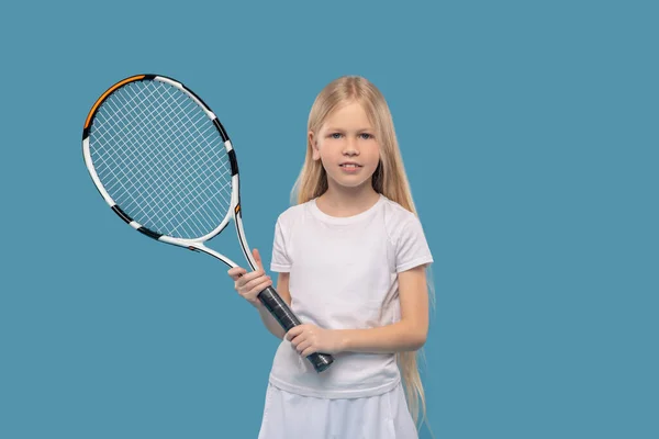 Счастливая школьница с теннисной ракеткой — стоковое фото