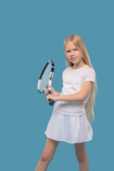 Dziewczyna w odzieży sportowej ćwiczy z rakietą tenisową — Zdjęcie stockowe