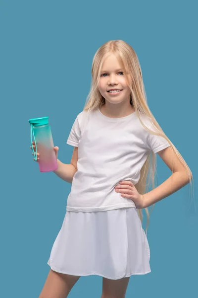 Smiling girl showing sports water bottle — Φωτογραφία Αρχείου