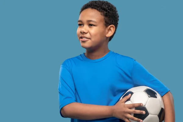 Joyful interessado menino segurando bola de futebol — Fotografia de Stock