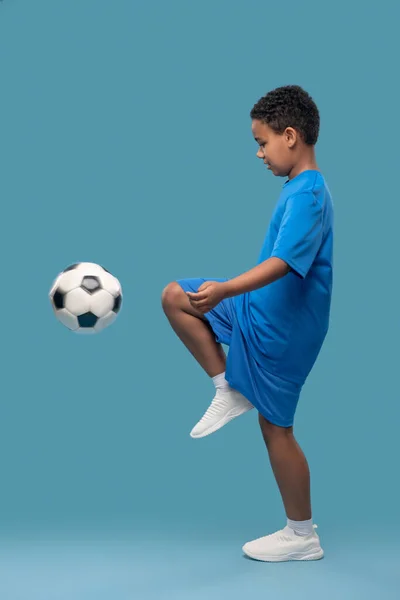 Perfil de boy kneeing soccer ball — Fotografia de Stock