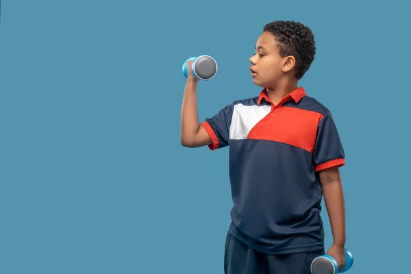 Rapaz afro-americano sério a fazer exercício de halteres — Fotografia de Stock