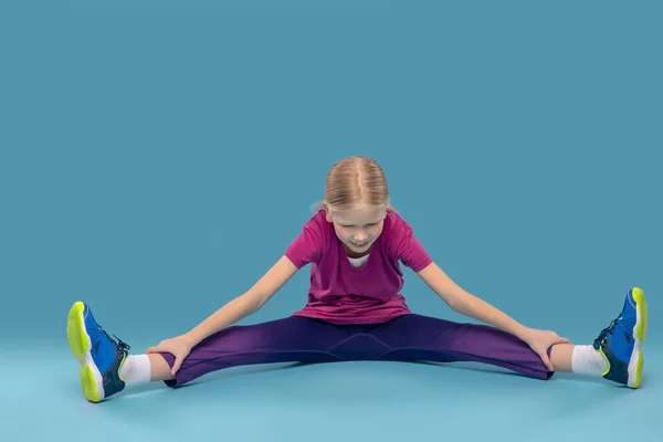 Dziewczyna na podłodze robi ćwiczenia rozciągające — Zdjęcie stockowe