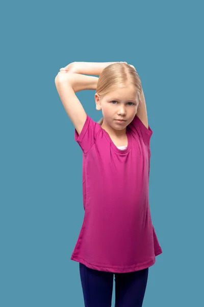 Сосредоточенная девушка делает упражнения на растяжение рук — стоковое фото
