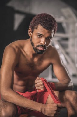 Esmer tenli genç sporcu spor için hazırlanıyor.