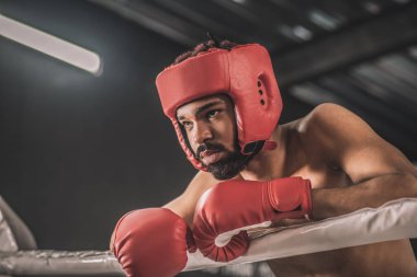 Kırmızı etekli siyah tenli boksör kavgadan sonra dinleniyor.