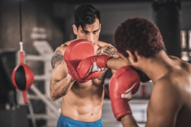 İki kickboksör spor salonunda tekmeler üzerinde çalışıyor.