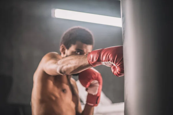 Koyu tenli kickboksör spor salonunda antrenman yapıyor. — Stok fotoğraf