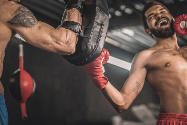 Koyu tenli kickboksör tekmesini spor salonunda eğitiyor. — Stok fotoğraf