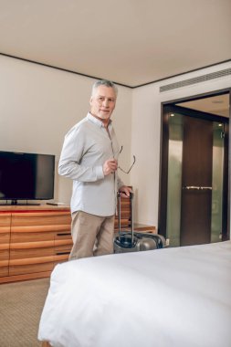 Gri saçlı yakışıklı adam otele geldi.