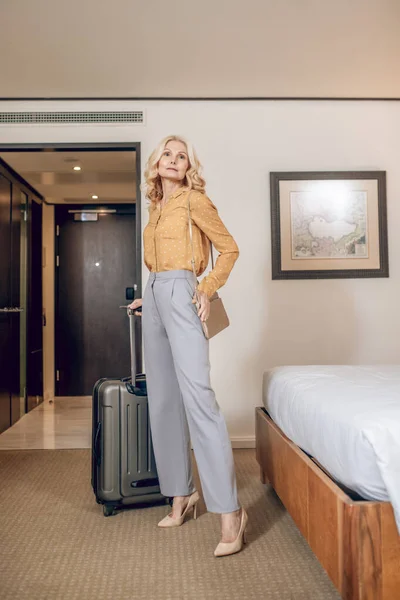 Otel odasında bavullu sarışın zarif bir kadın. — Stok fotoğraf