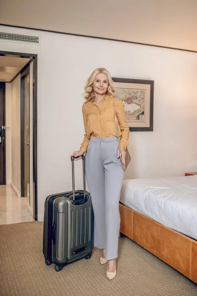 Otel odasında bavullu sarışın zarif bir kadın. — Stok fotoğraf