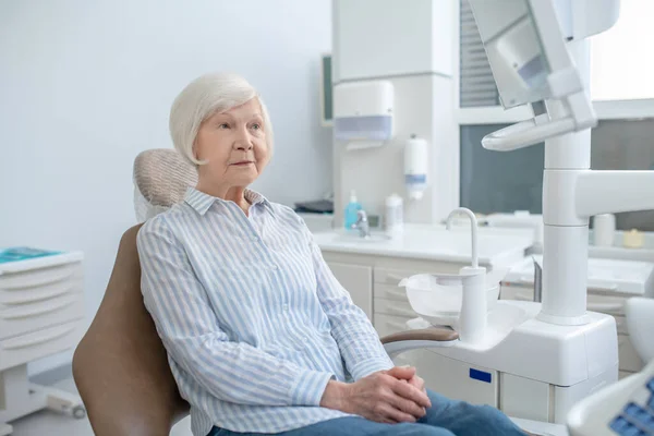 나이든 여자 가 치과에 앉아서 의사를 기다리고 있습니다 — 스톡 사진