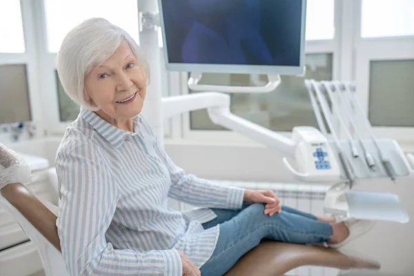 Gray-haired woman sitting at the dentists office and waiting for the doctor — Φωτογραφία Αρχείου