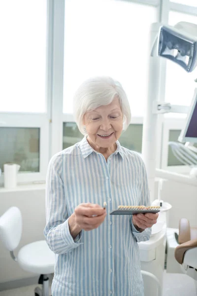 Senior woman at the dentists office with denture in hands — Φωτογραφία Αρχείου