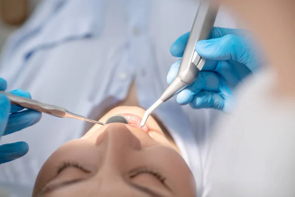 Zahnarzt arbeitet an der Wiederherstellung der Zähne von Patienten und macht Zahnbohrungen — Stockfoto