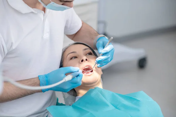 Dentista trabalhando na restauração dos dentes dos pacientes e fazendo enchimento dentário — Fotografia de Stock