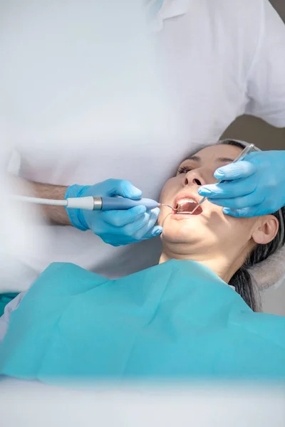 Dentista trabalhando na restauração dos dentes dos pacientes e fazendo enchimento dentário — Fotografia de Stock