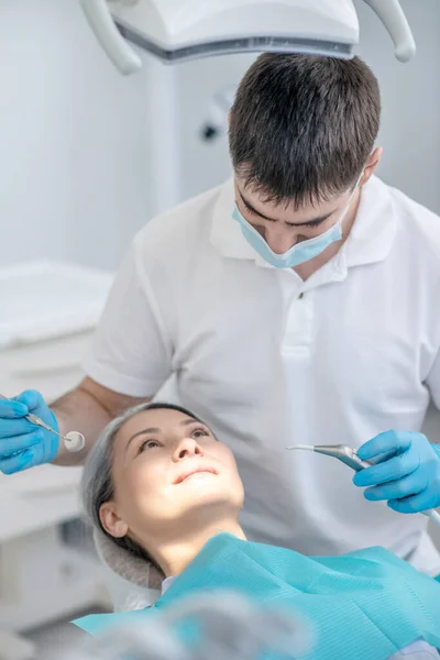 Dentista trabalhando na restauração dos dentes dos pacientes e fazendo enchimento dentário — Fotografia de Stock