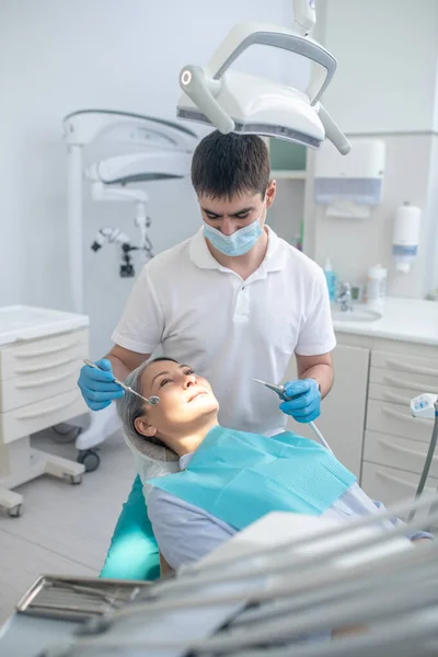 Dentista trabalhando na restauração dos dentes dos pacientes e fazendo enchimento dentário — Fotografia de Stock