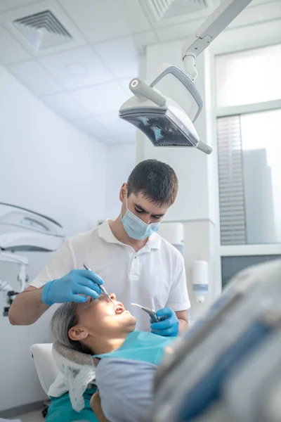 환자와 함께 일하며 치아를 복구하는 남성 치과 의사 — 스톡 사진