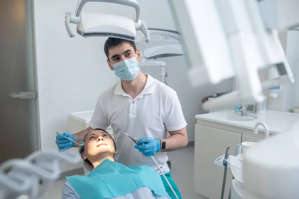 Dentista masculino trabalhando com um paciente e fazendo restauração dos dentes — Fotografia de Stock